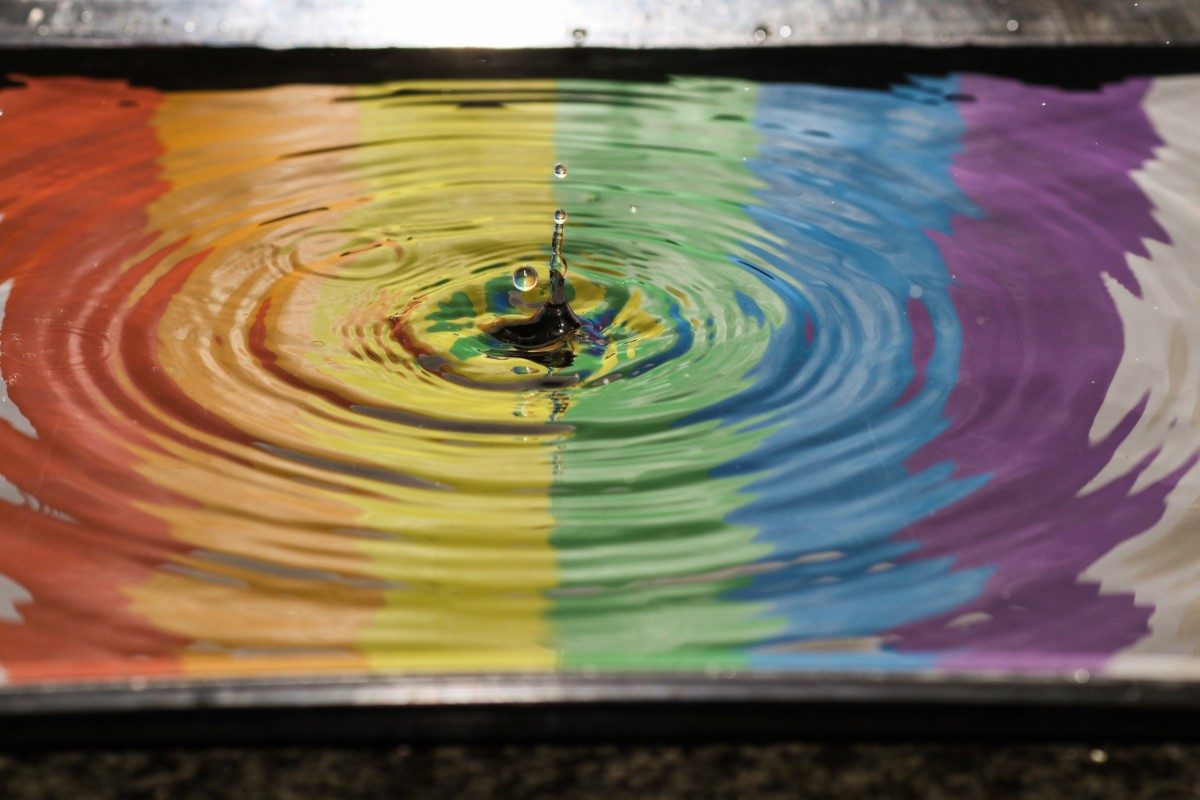 reflection of a rainbow in a puddle of water lgbtq